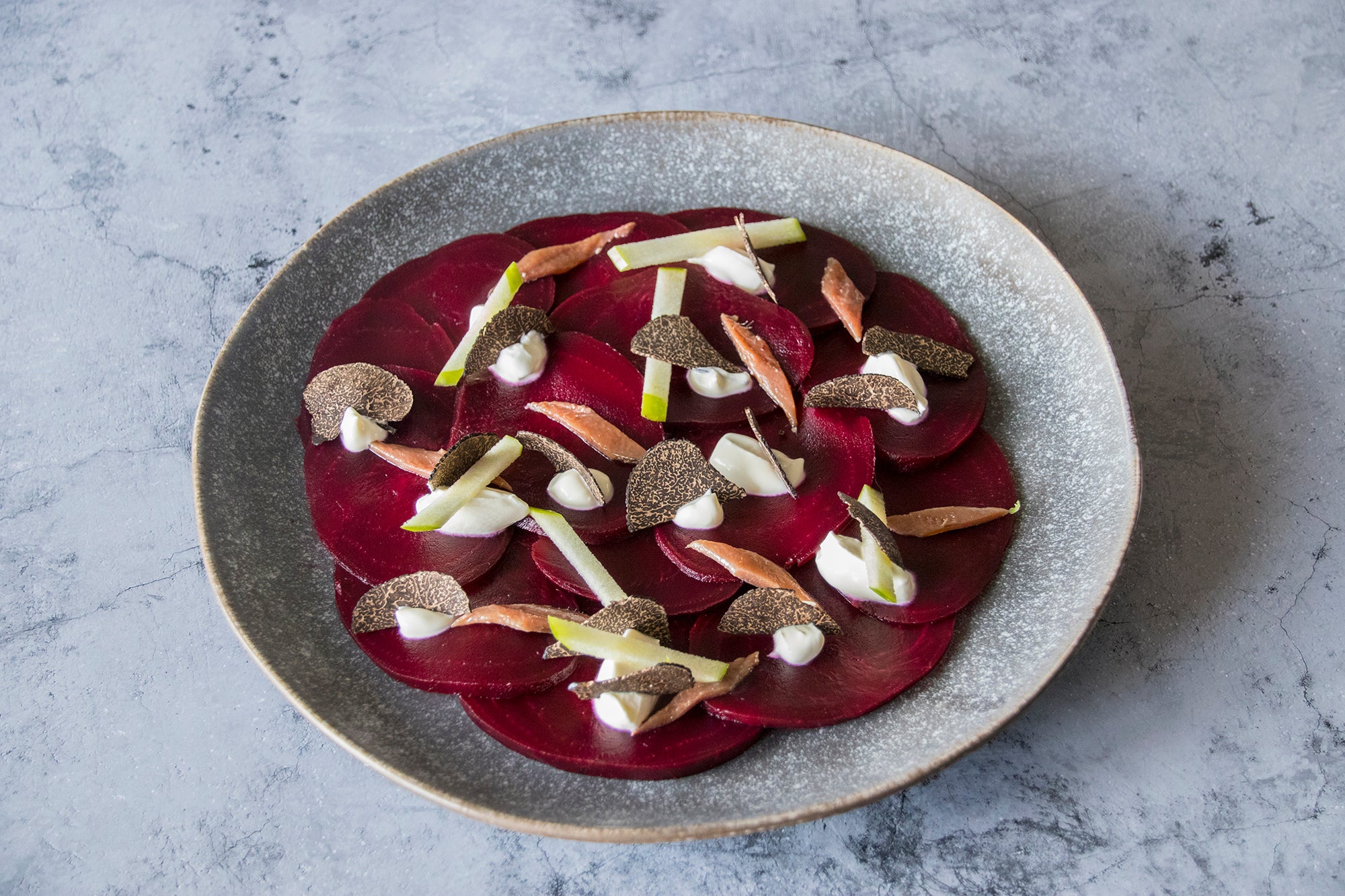 Carpaccio de remolacha y crème fraîche, manzana, anchoa y trufa negra