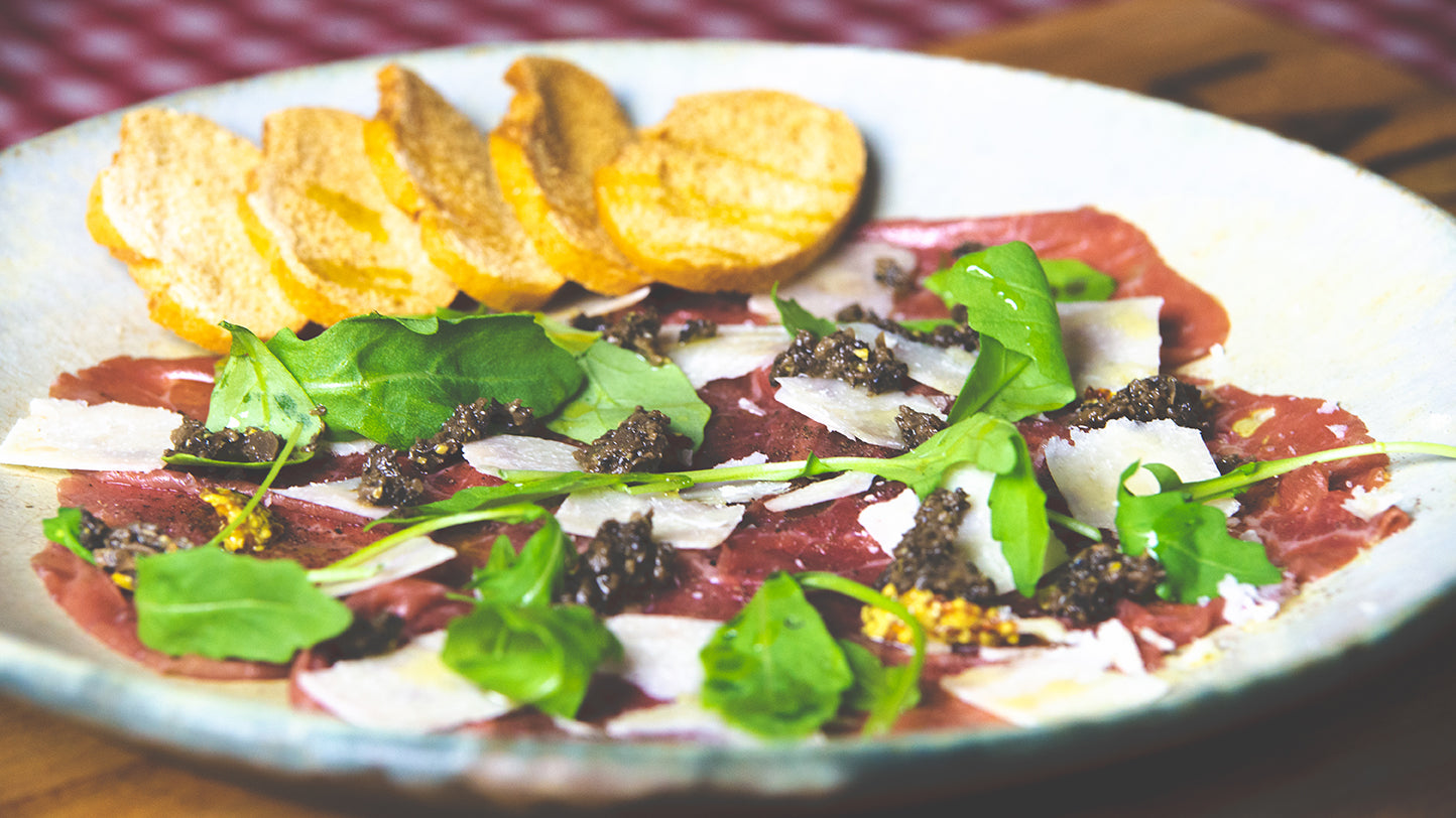 Carpaccio de ternera con parmesano, rúcula, mostaza antigua y tartufata